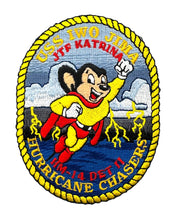 Lade das Bild in den Galerie-Viewer, An embroidered oval patch featuring a cartoon hurricane chaser mascot in a yellow and red suit running through blue water with white clouds and lightning. Text around the patch reads 'UCS IWO JINIA JTF KATRINA' at the top and 'HM-14 DET II HURRICANE CHASERS' at the bottom, with a yellow rope border.